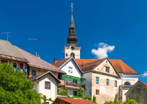 View of old residential houses in front of the Parish Church of St. Nicholas in Metlika, Slovenia.