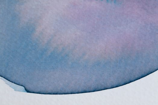 Swirls of blue and purple watercolor create a soft, dreamy effect on textured paper, evoking feelings of calmness and creativity through their delicate blending and fluidity.