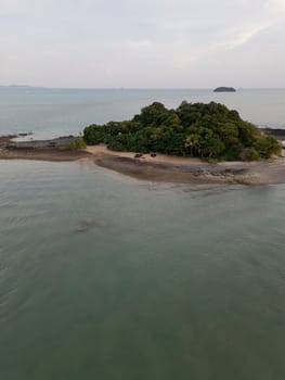 Aerial view of a majestic small Thai island with sailboats around the shore, amazing travel destination featuring crystal clear waters and dense rainforests. Tropical landscape.