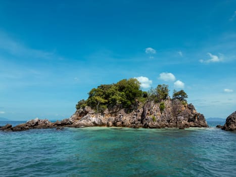 Breathtaking aerial view above a picturesque coastline showing dense forest trees, green jungle and turquoise ocean waters. Thailand is a perfect travel destination for adventure seekers.