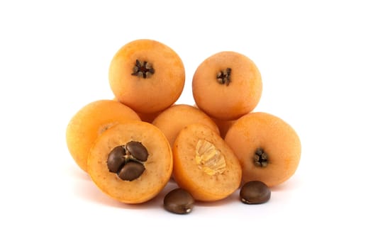 Several loquat fruits resting on a white background, with some cut in half revealing vibrant seeds, juicy pulp, and textured peel, highlighting their fresh and delicious appeal