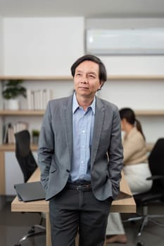 A businessman stands confidently with arms crossed in a sleek office, embodying professionalism and leadership.