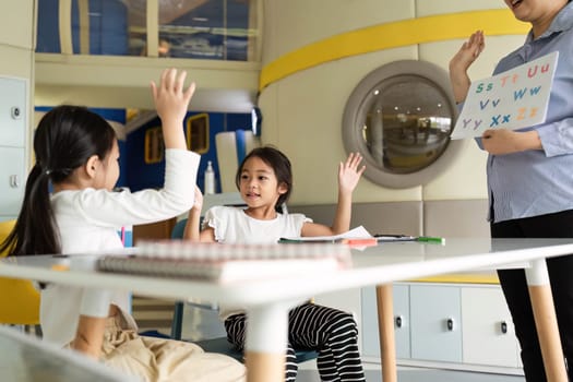 Two girls excitedly participate in a back-to-school lesson, showcasing enthusiasm and eagerness to learn.
