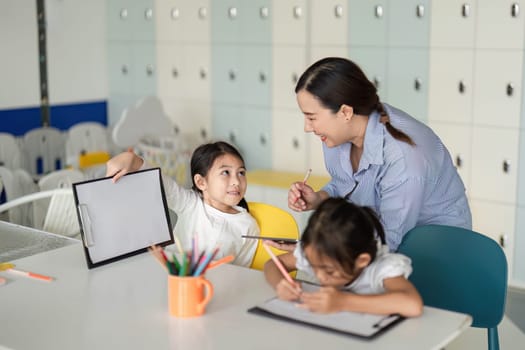 A teacher interacts with children in a vibrant classroom, fostering a positive learning environment as they prepare for school.
