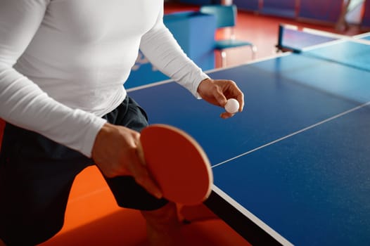 Closeup view on male athlete hands holding racket and ball to play ping pong. Serve in tennis concept
