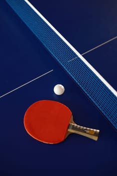 Table tennis equipment on blue ping pong table with grid net. Sport club and training class for skills improvement. Tennis still life