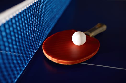 Table tennis equipment on blue ping pong table with grid net. Sport club and training class for skills improvement