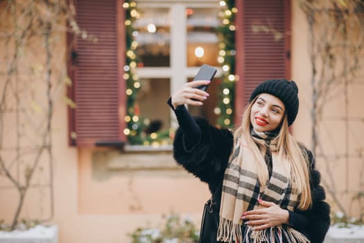 Making selfie with smartphone. Portrait beautiful girl making selfie photo on smartphone at street. Sexy woman photographing in luxury clothing outdoor. Woman taking self portrait near city street.