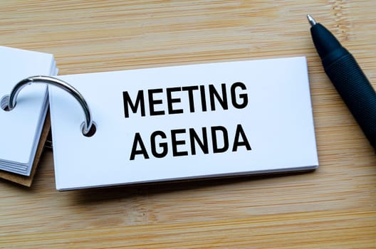 Meeting Agenda text on notepad illustrating structured planning and organized discussion points.