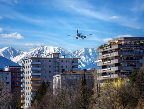 Plane flying over Innsbruck city approaching the airport