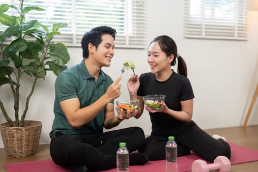 A couple engaged in a healthy eating moment, promoting nutrition and connection in their fitness journey at home.