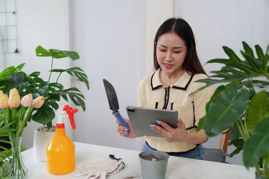A gardening enthusiast utilizes her tablet to learn about plant care, highlighting the blend of technology and nature in modern hobbies.