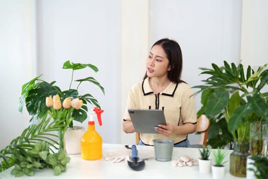 Documenting her gardening journey on a tablet, the woman shares insights on sustainable care for her plants, fostering a green lifestyle.