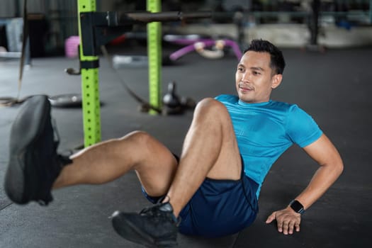 Focused man performing bicycle crunches in a gym, emphasizing core strength and dedication to fitness.