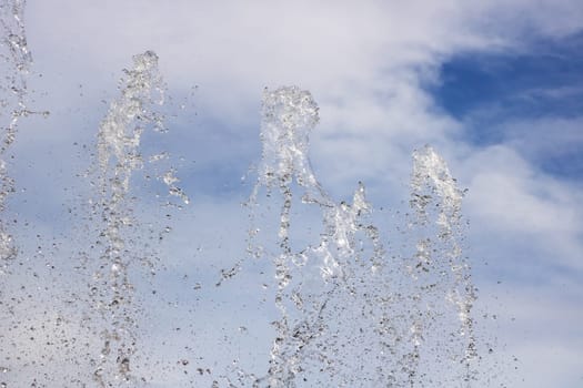 A beautiful fountain surrounded by water, set against a stunning blue sky in the background, showcasing its elegant design and allure