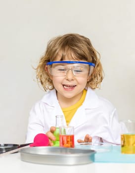 Laboratory examination of a child with test tubes, reagents and a microscope. Selective focus. kid.