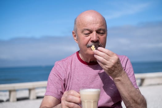 Elderly Man with Mustache Drinking Coffee at Outdoor Cafe on Vacation near sea