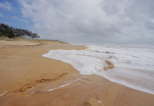 Foamy surf waves rolling in during Rough Weather from Tropical Cyclone Alfred at Buddina Beach on Sushine Coast Maroochydore Queensland