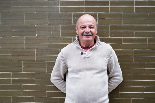 Elderly Spanish Man Standing by a Wall and Smiling. High quality photo