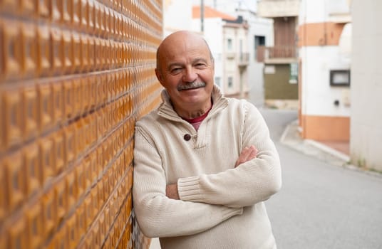 Elderly Spanish Man Standing by a Wall and Smiling. High quality photo
