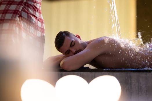 Water Treatment in Turkish Hammam.Man receiving water therapy inside a traditional Turkish hammam with ornate details.
