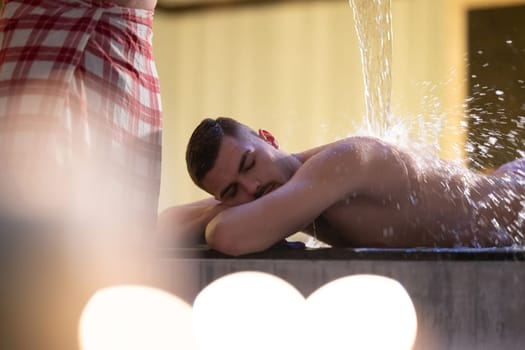 Water Treatment in Turkish Hammam.Man receiving water therapy inside a traditional Turkish hammam with ornate details.