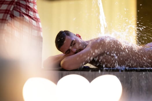 Water Treatment in Turkish Hammam.Man receiving water therapy inside a traditional Turkish hammam with ornate details.