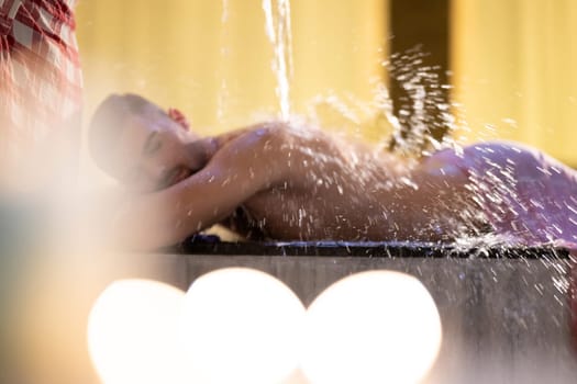 Water Treatment in Turkish Hammam.Man receiving water therapy inside a traditional Turkish hammam with ornate details.