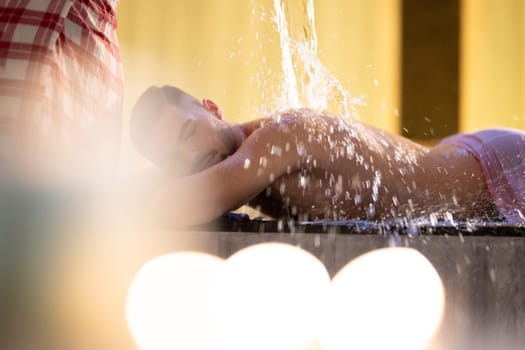 Water Treatment in Turkish Hammam.Man receiving water therapy inside a traditional Turkish hammam with ornate details.