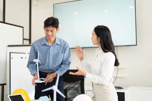Engineers explore renewable energy solutions, discussing wind turbine models and sustainable practices, emphasizing innovation in engineering and environmental responsibility.