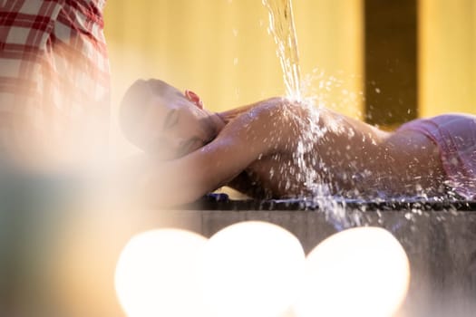 Water Treatment in Turkish Hammam.Man receiving water therapy inside a traditional Turkish hammam with ornate details.