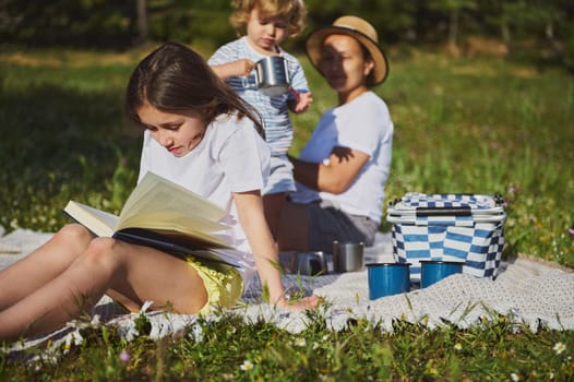 A serene image of a family spending quality time together on a peaceful grass field. The sunlight enhances the warmth of their outdoor picnic, highlighting a carefree, joyful moment.