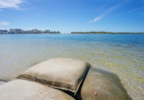 Looking across from sandbags used for erosion on Golden Beach towards Caloundra City buildings and  Bulcock Beach and across to the vegetation on the northern tip of Bribie Island