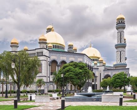 Stunning architecture of Jame' Asr Hassanil Bolkiah Mosque in Bandar Seri Begawan, Brunei. The golden dome glistens under a colorful sky, creating a peaceful atmosphere