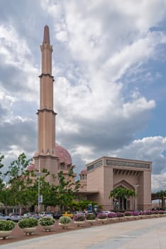 Putrajaya, Malaysia - February 20, 2025: Putra Mosque, Exterior view of the pink mosque with minaret and dome under cloudy sky