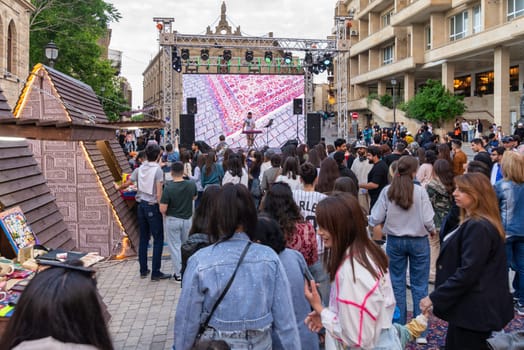 Baku, Azerbaijan - May 4 2024: Substantial crowd gather for a concert at the First National Carpet Festival of Azerbaijan. The event was held in the Old Town, or Icherisheher, the historic walled city