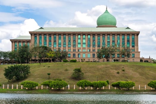 Perdana Putra, Prime Minister's Office, Putrajaya, Malaysia. Iconic government building with green dome, columns, and lake view under cloudy sky
