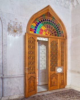 Vibrant stained glass decorates a wooden door at Bibi-Heybat Mosque in Baku, Azerbaijan, showcasing rich cultural heritage and architectural elegance