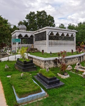 Bandar Seri Begawan, Brunei - Feb. 26, 2025: Located in Batu Satu, the Royal Mausoleum, Malay: Kubah Makam Diraja, featuring a dome and arched windows, and an ARAH KIBLAT sign, on a cloudy day