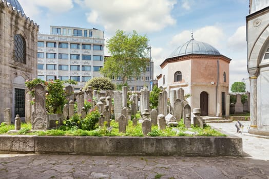 The Ottoman cemetery at Sehzade Mosque complex in Istanbul, Turkey, features intricate gravestones surrounded by lush greenery