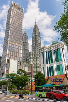 Kuala Lumpur, Malaysia - February 17, 2025: In this bustling metropolis, the towering Petronas Towers stand proudly amidst the urban skyline, harmoniously juxtaposed with the contemporary Maxis Tower