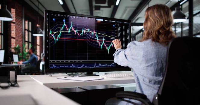 Professional Businesswoman Using Computer To Trade Stocks In Company Office