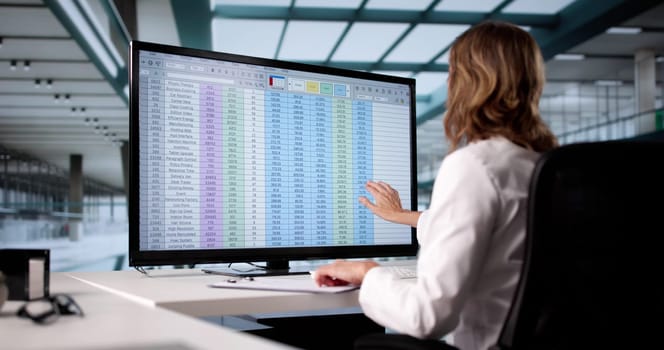 Woman Using Medical Coding Bill And Billing Codes Spreadsheets In Office
