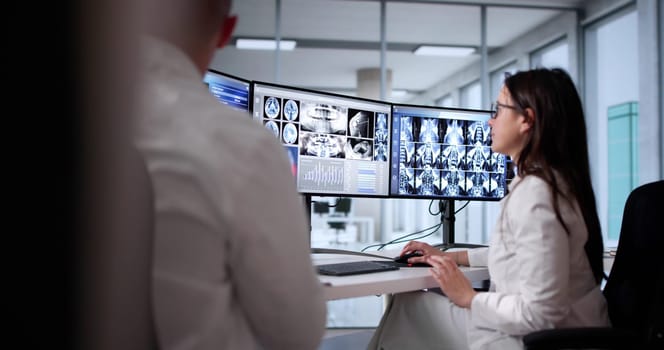 Radiologist Doctors Collaborating On Brain MRI Scan In Medical Clinic