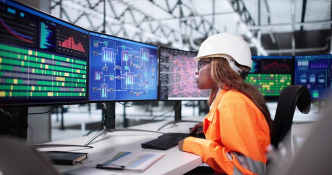 African American Woman Uses SCADA Software To Monitor Semiconductor Production.