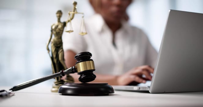An African American Female Lawyer Typing On Her Laptop In Court.