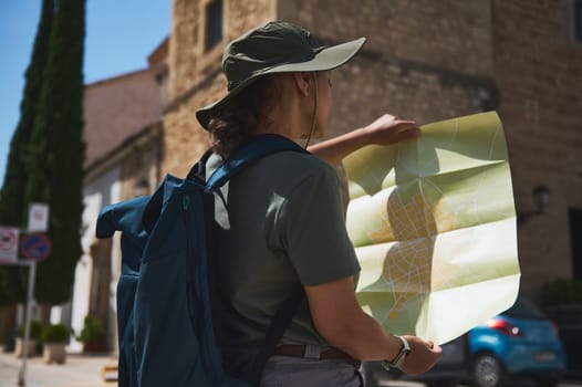 Traveler exploring a historic Spanish town, studying a map for directions. Captures the essence of outdoor adventures, cultural exploration, and navigating unknown destinations.