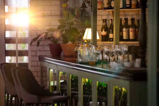 Part of the interior of a cozy restaurant with a bar counter with glasses and a cabinet for wine.