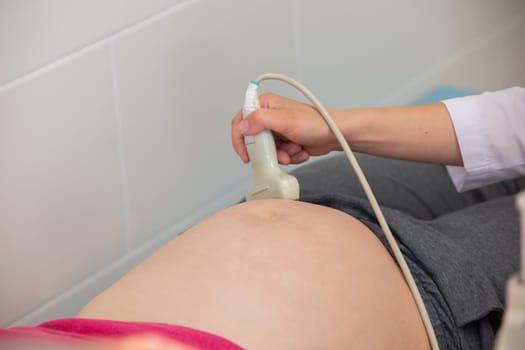 The doctor makes an ultrasound examination of a pregnant woman.