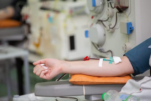 Close-up of a woman's hand while donating blood at a blood donation center.